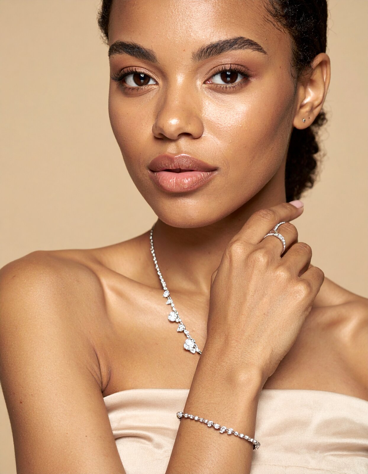 Woman wearing a 1CaratDiamond diamond tennis bracelet, necklace and ring