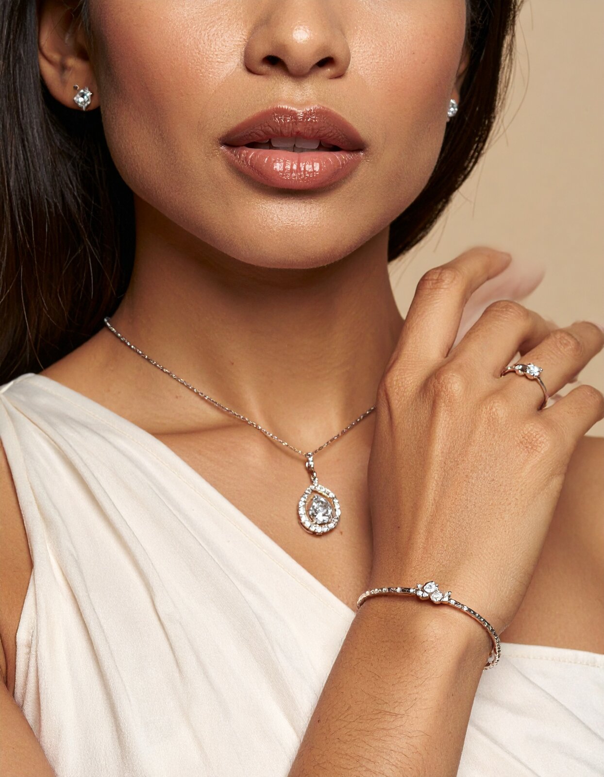Close portrait of a woman wearing a 1CaratDiamond ring and earrings